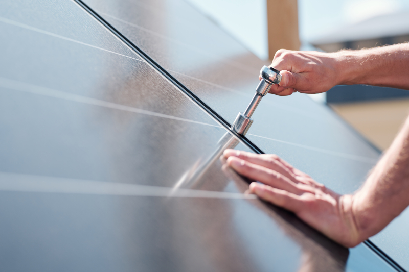 Hands of contemporary master with screw adjusting or installing solar panels Reparaturen